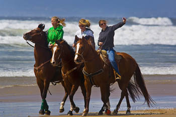Girls riding horses on beach