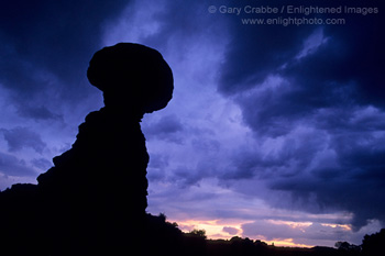 Dark storm clouds over Balanced Rock at sunset, Arches National Park, Utah
