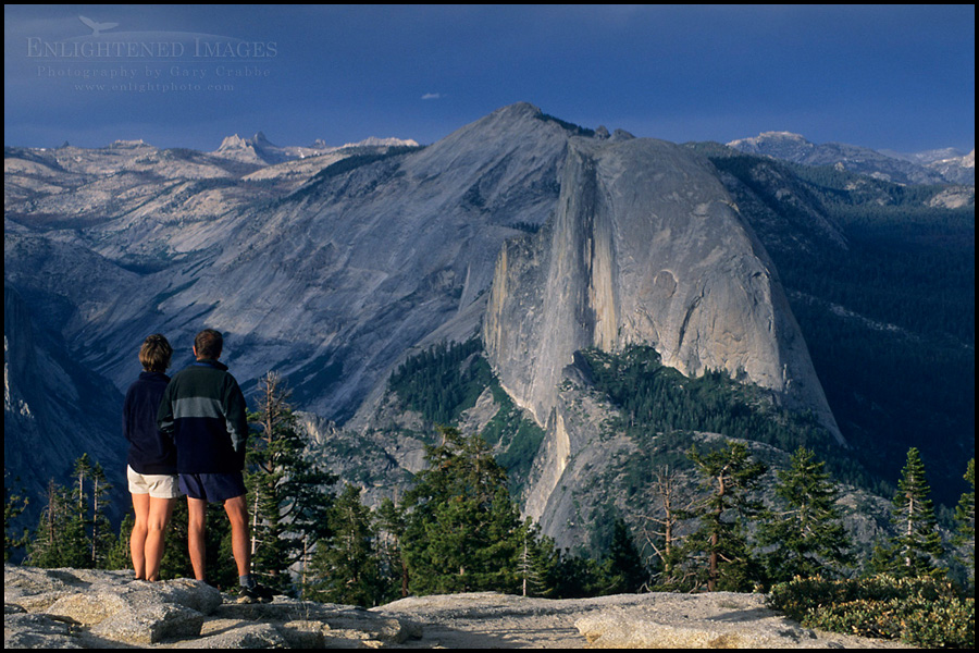 Photo: Hikers looking towards Half Dome and Tenaya Canyon from atop Sentinel Dome, Yosemite National Park, California Image: Hikers looking towards Half Dome and Tenaya Canyon from atop Sentinel Dome, Yosemite National Park, California