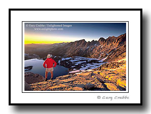 Hiker overlooking mountains and alpine lake at sunset, Yosemite, California