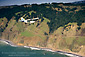 Small single-engine plane flying over the California coastal cliffs, Sonoma County, California