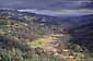 Sunlight through storm clouds on the rugged hills and stream in valley near Mount Hamilton, rural Santa Clara County, California