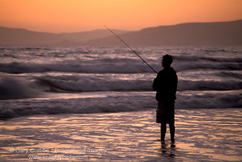 Young man surf fishing at sunset, Morro Strand State Beach, Central Coast, California; Stock Photo photography picture image photograph fine art decor print wall mural gallery