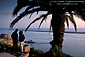 Tourist Couple looking out over Pacific Ocean at sunset, from Inspiration Point overlook, Corona del Mar, Newport Beach, California
