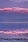 Sunrise light on Panamint mountains reflected in spring flood waters in desert basin, near Badwater, Death Valley National Park, California