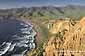 Green hills in spring surround the waves breaking on Christies Beach, Santa Cruz Island, Channel Islands, California