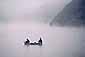 Two fishermen lake fishing from small boat on a misty morning, San Mateo Coast, California