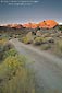Picture: Dirt road and alpenglow at sunrise on high mountain peaks, Eastern Sierra, California