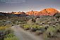 Picture: Dirt road below mountain peaks at sunrise, Eastern Sierra, California