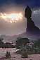 Sunburst through misty morning storm clouds next to Balanced Rock, Arches National Park, Utah
