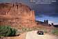 Driving below red cliffs near Park Avenue, Arches National Park, Utah