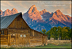 Sunrise light on the Grand teton mountain peak over old wooden barn, Mormon Row, Grand Teton National Park, Wyoming